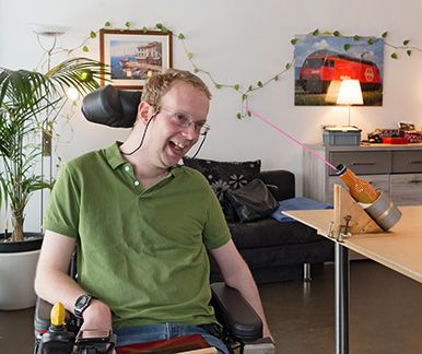 Un uomo con paralisi cerebrale ride nel suo salotto