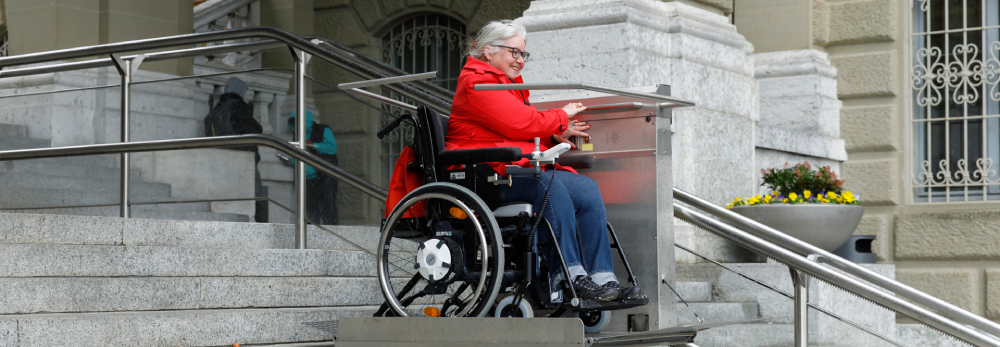 Donna in sedia a rotelle davanti al Palazzo federale di Berna