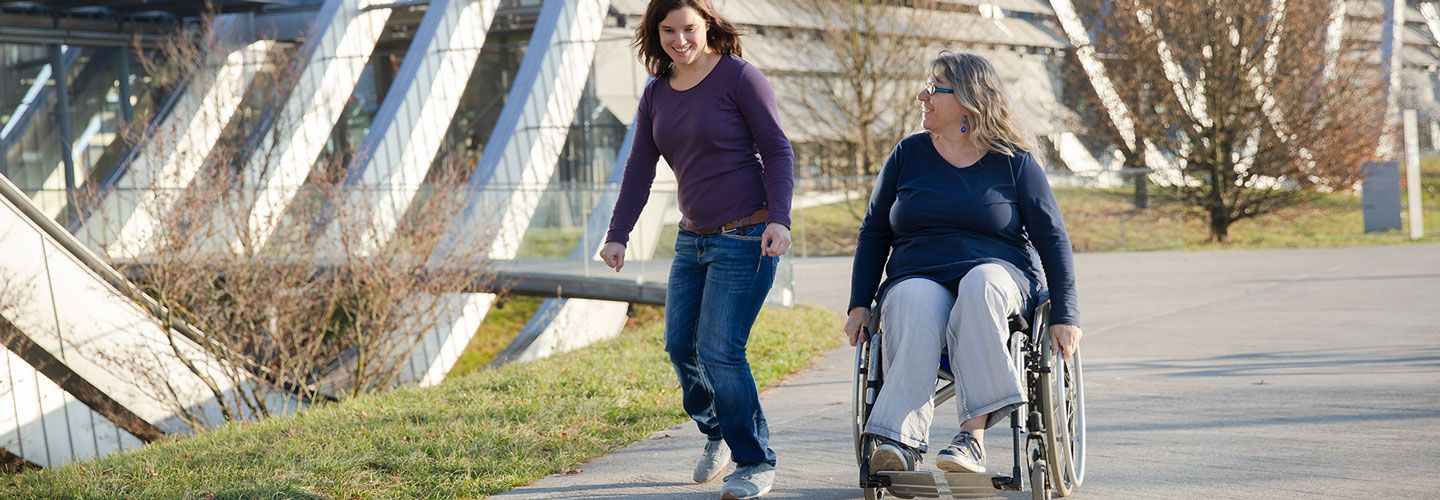 Zwei Frauen auf einem Spaziergang, eine davon im Rollstuhl