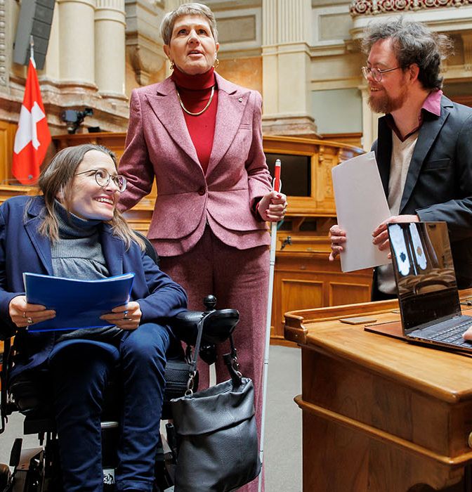 Tre persone con disabilità nella sala del Consiglio nazionale di Palazzo federale