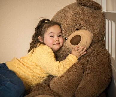 Mädchen kuschelt mit Teddybär