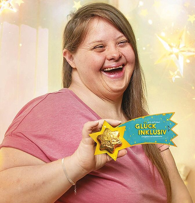 Person hält Schoggistern von der Weihnachtsaktion von Pro Infirmis in die Kamera}