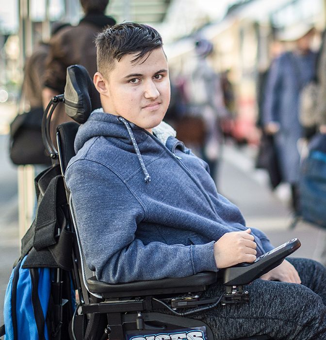 Junger Mann mit Rollstuhl steigt ins Tram ein.}