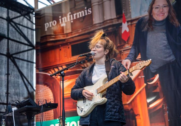 Ginger and the Alchemists bei ihrem Auftritt bei dem Event auf dem Bundesplatz mit Gitarre am Mikrofon