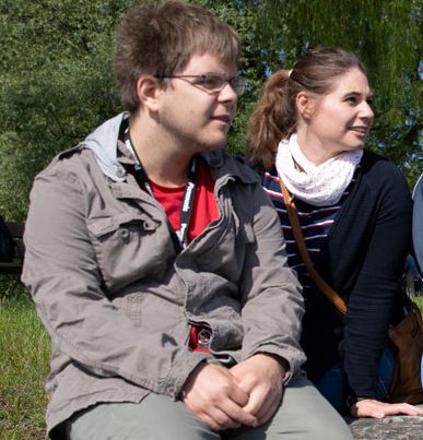 Drei junge Menschen sitzen draussen
