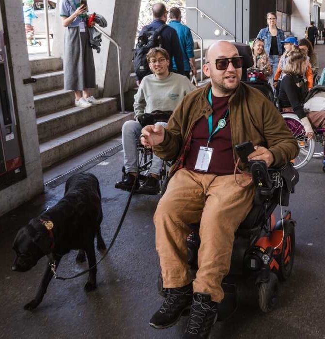Personnes en fauteuil roulant sur un quai de gare.