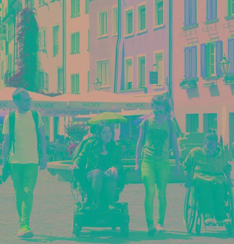 Eine Gruppe von Menschen (zwei im Rolltstuhl) in Chur