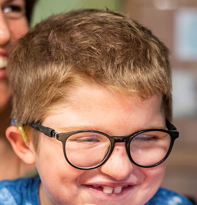 )) Levin seduto in grembo alla mamma, entrambi ridono.}