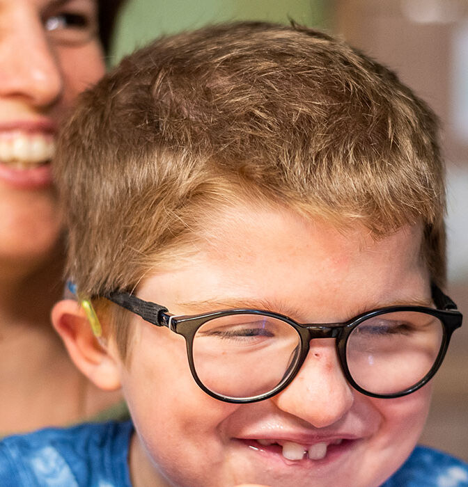 Levin sur les genoux de sa maman, souriants tous les deux.}