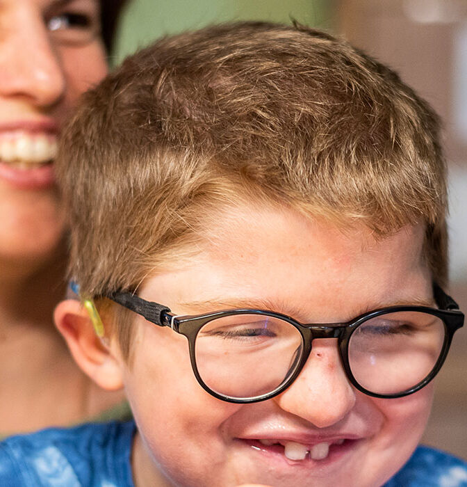 Levin sitzt auf dem Schoss seiner Mutter, beide lachen.}