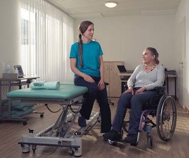 Une physiothérapeute et sa cliente en fauteuil roulant se regardent. Une physiothérapeute et sa cliente en fauteuil roulant se regardent.
