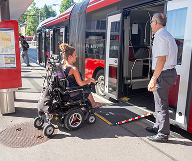 Eine Person im Rollstuhl beim Einstieg in den Bus