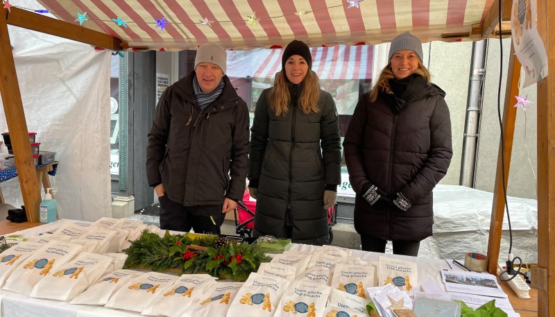 Trois personnes à un stand de bonshommes en pâte au marché de Noël de Frauenfeld.