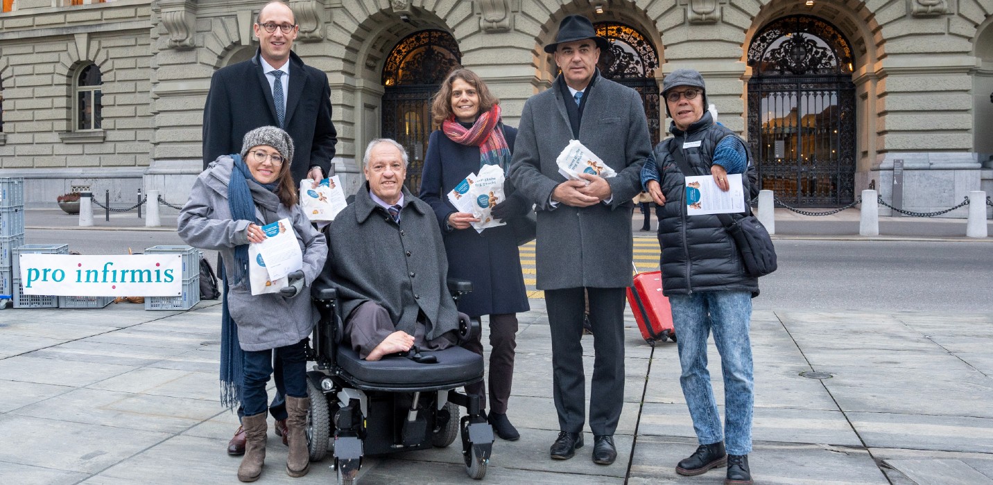 Diverse persone con confezioni di Grittibänz davanti a Palazzo federale.