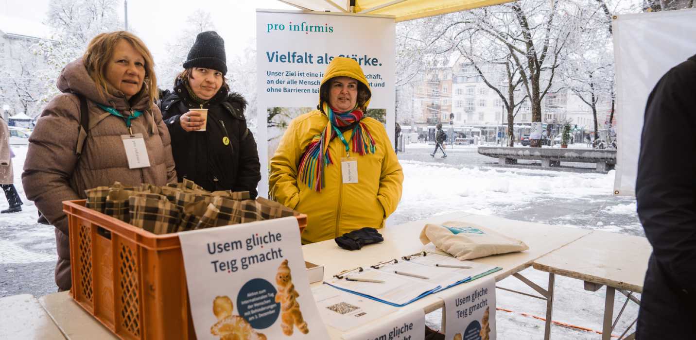 Eine Gruppe von Menschen steht an einem Grittibänz-Stand