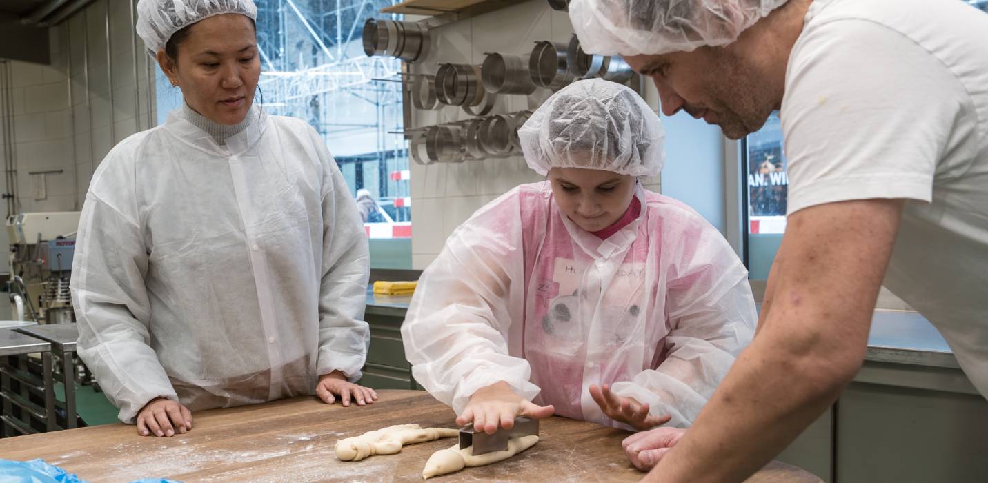 Des personnes confectionnent des bonshommes de St-Nicolas dans un atelier de boulangerie