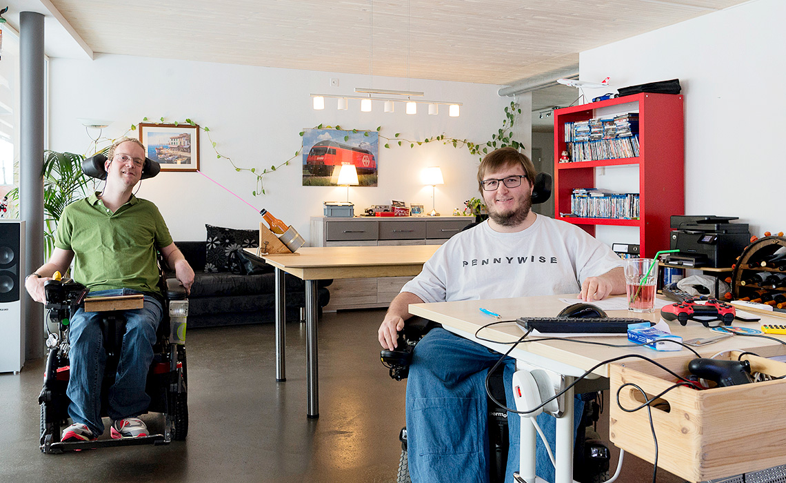 Die Rollstuhlfahrer Lukas und Peter in ihrer Wohnung