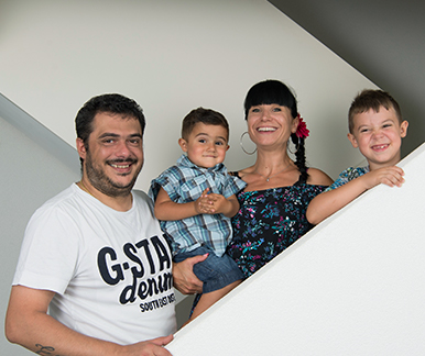 Familie mit Vater, Mutter und zwei kleinen Jungen auf einer Treppe